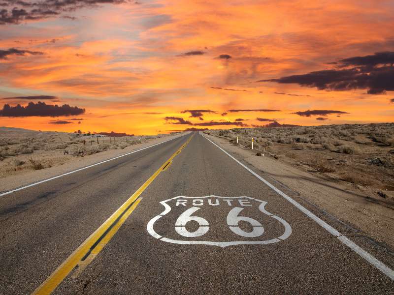 Historic Route 66 highway shield painted on the road at sunset, representing the classic Victorville, CA lifestyle.